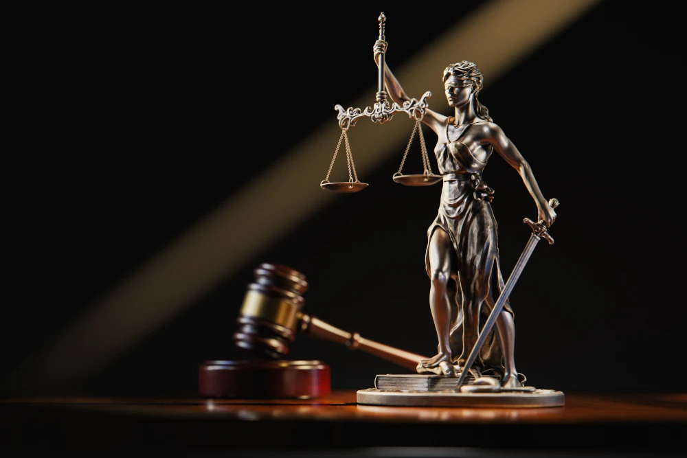 Justitia-Statue mit Richterhammer – Symbolbild für Gerichtsurteil wegen Verletzung der Sorgfaltspflicht.